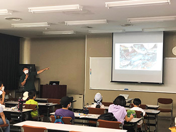 亀岡人と自然のネットワークの宇野さんのヤマトサンショウウオの説明スライドのようす