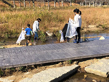 TANAKAMI子ども環境クラブ　橋の周りの流れからゴミを拾う子どもたち