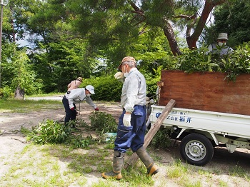 吉田山の里山を再生する会　軽トラックに枝葉を切りそろえて積む