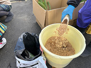 京都発・竹・流域環境ネット　器に入れる竹の粉と土（黒いビニール袋）