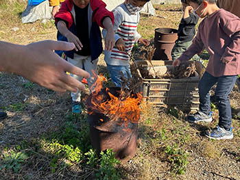 西の湖自然楽校　焚火にヨシ材をくべる子どもたち
