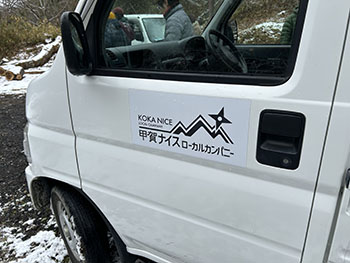 一般社団法人　甲賀ナイスローカルカンパニー　活動のようす画像　　　甲賀ナイスローカルカンパニーのロゴがドアに貼り付けてある白い軽トラ