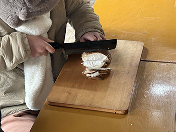 一般社団法人　甲賀ナイスローカルカンパニー　活動のようす画像　子どもが包丁で握りこぶし大のシイタケを切っている　　