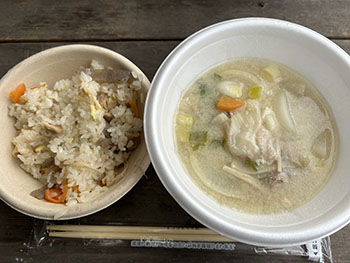 一般社団法人　甲賀ナイスローカルカンパニー　活動のようす画像　　　紙のお皿に盛りつけられたかやくご飯と、右側には発泡スチロールの丼に盛り付けられた豚汁