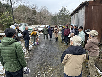 一般社団法人　甲賀ナイスローカルカンパニー　活動のようす画像　参加者が丸く集まり、代表の藤井さんがあいさつされているところ。雪のちらつく寒い日